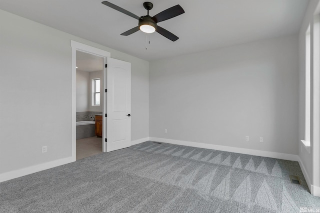 unfurnished bedroom featuring ceiling fan, carpet flooring, and ensuite bath