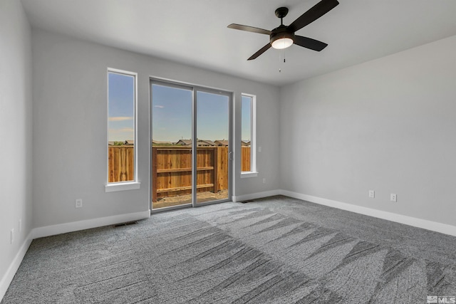 carpeted spare room featuring ceiling fan