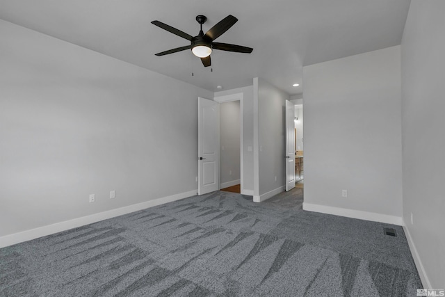 unfurnished bedroom with ceiling fan and dark colored carpet