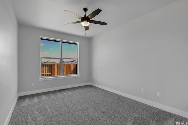 carpeted spare room featuring ceiling fan