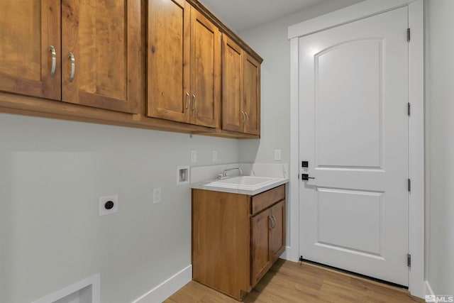 laundry area featuring washer hookup, hookup for an electric dryer, sink, light hardwood / wood-style floors, and cabinets