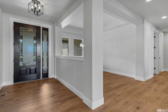 entrance foyer with light hardwood / wood-style flooring and an inviting chandelier