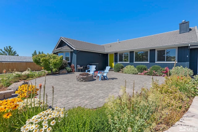 rear view of house with a patio area and an outdoor fire pit