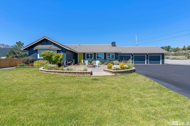 single story home featuring an outbuilding, a garage, and a front lawn