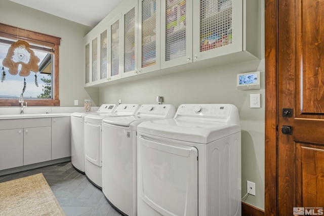 laundry room with sink, washing machine and dryer, tile patterned flooring, and cabinets