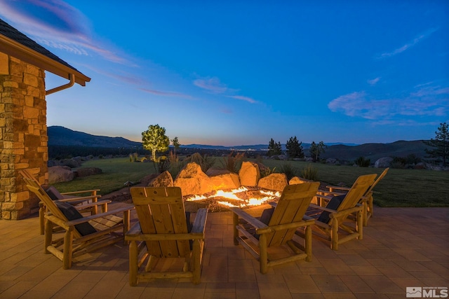 patio terrace at dusk with a mountain view and a fire pit