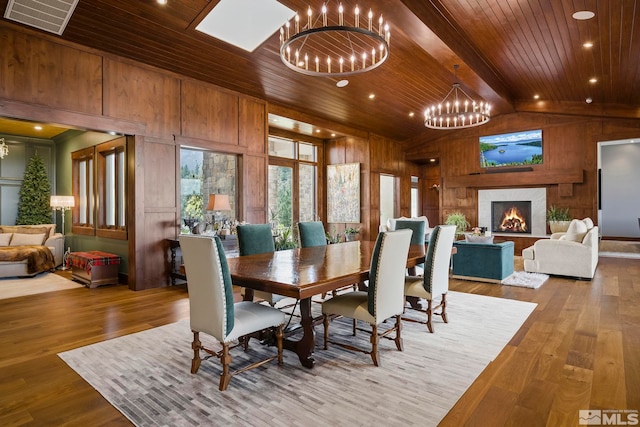 dining room with wooden walls, wooden ceiling, hardwood / wood-style flooring, and a notable chandelier