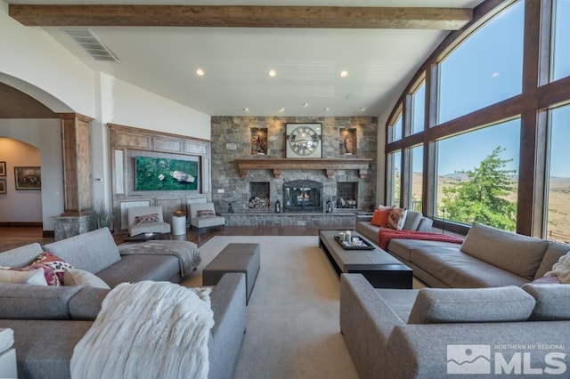 living room with a high ceiling, beam ceiling, light wood-type flooring, and a fireplace