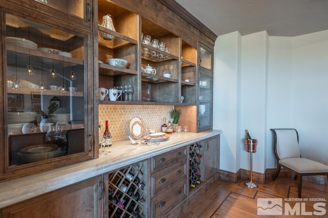 bar with parquet flooring, tasteful backsplash, and dark brown cabinets