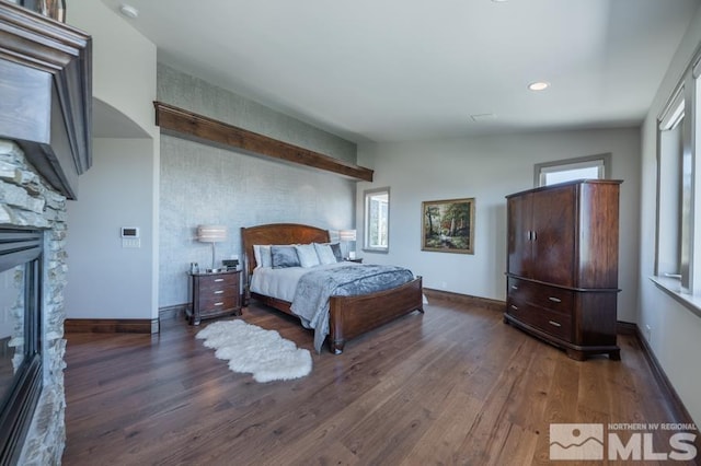 bedroom featuring lofted ceiling, dark wood-type flooring, and a fireplace