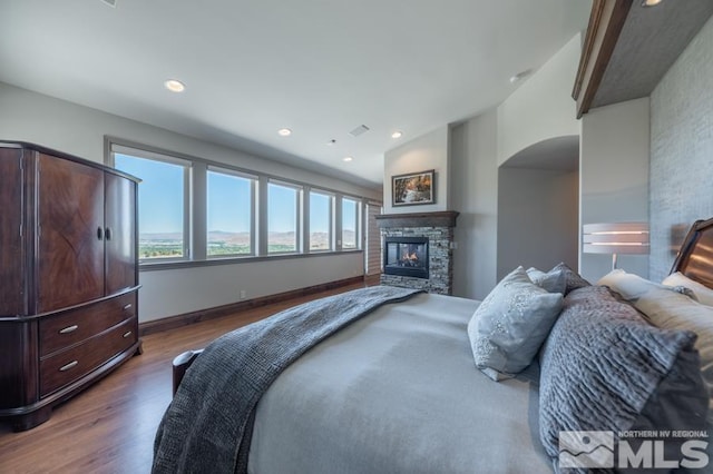 bedroom featuring lofted ceiling, dark hardwood / wood-style floors, and a fireplace