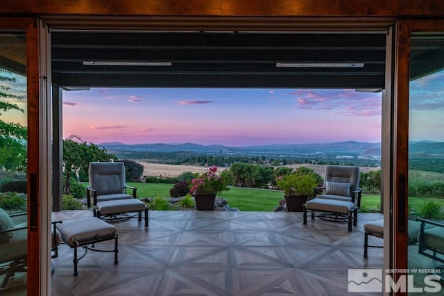 patio terrace at dusk featuring a mountain view