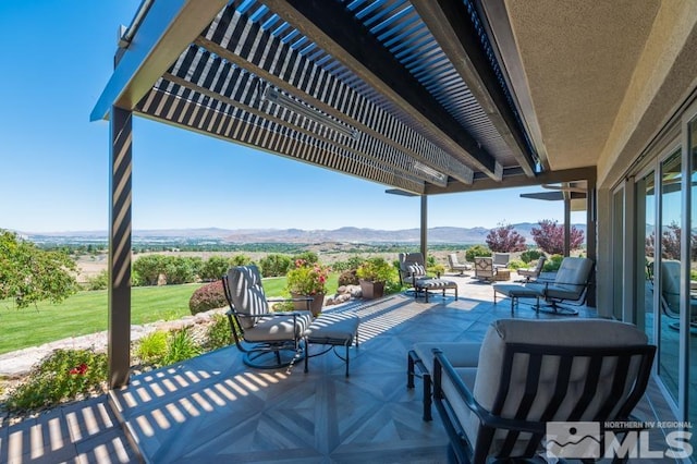 view of patio / terrace featuring a pergola, an outdoor living space, and a mountain view