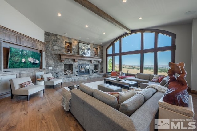 living room with a stone fireplace, high vaulted ceiling, light wood-type flooring, and beam ceiling