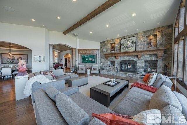 living room with lofted ceiling with beams, dark hardwood / wood-style floors, and a fireplace