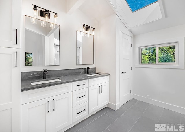 bathroom with tile flooring, lofted ceiling, large vanity, and dual sinks