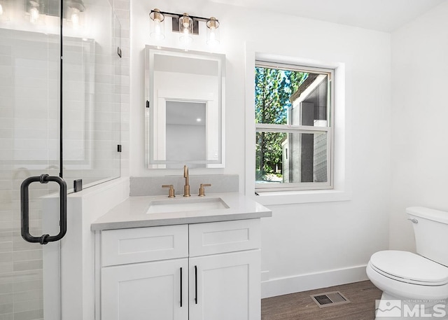 bathroom featuring oversized vanity, hardwood / wood-style flooring, toilet, and walk in shower