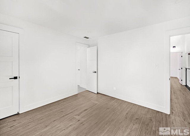 spare room with wood-type flooring