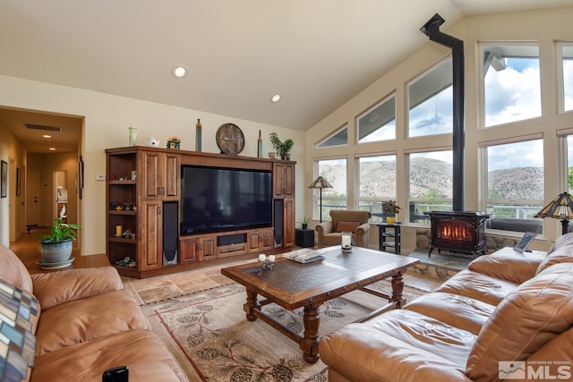 tiled living room featuring a wood stove and high vaulted ceiling