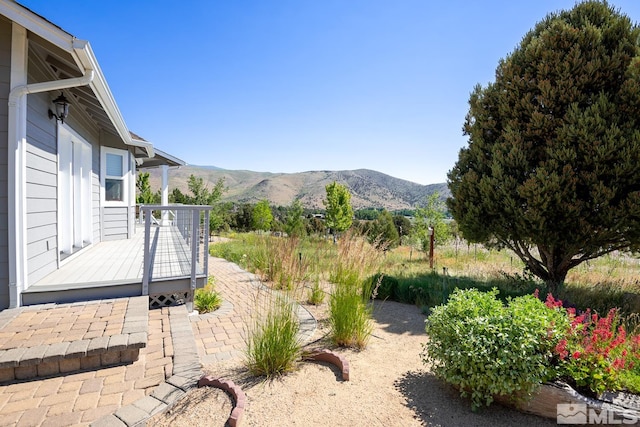 view of yard with a deck with mountain view