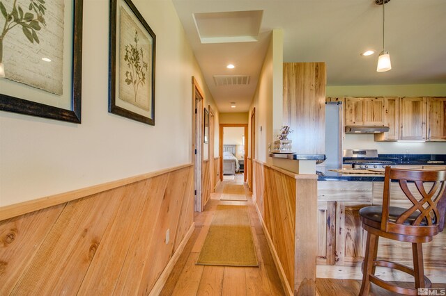 interior space featuring a kitchen breakfast bar, range, light hardwood / wood-style floors, and decorative light fixtures