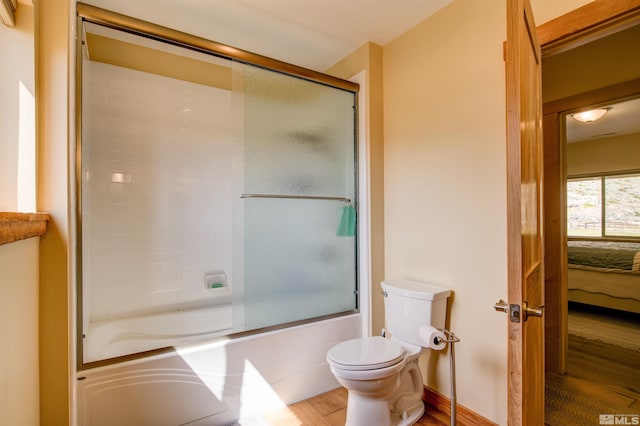 bathroom with shower / bath combination with glass door, toilet, and wood-type flooring