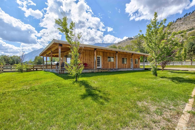 back of property with a yard and a mountain view