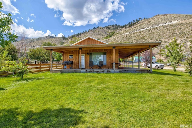 rear view of property with a yard and a mountain view