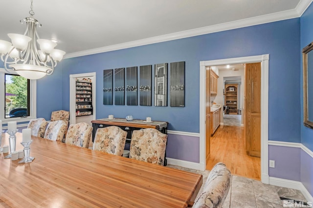 dining area featuring an inviting chandelier, ornamental molding, and light wood-type flooring