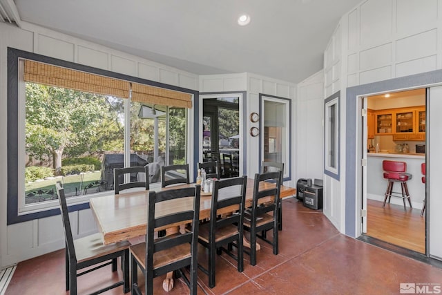 dining room featuring a wealth of natural light and vaulted ceiling