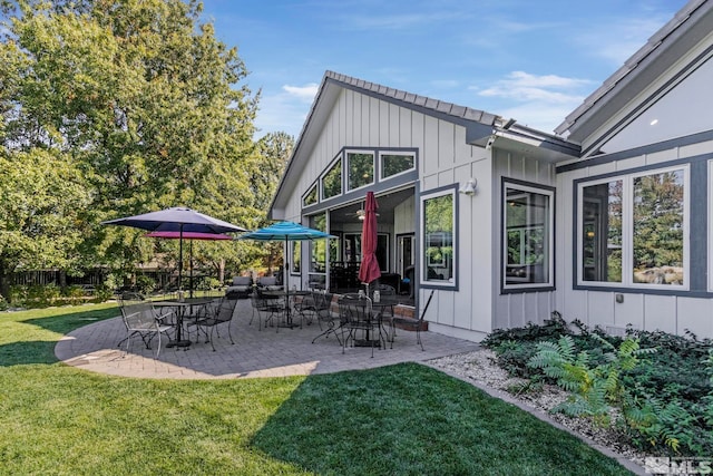 back of property featuring a patio area and a yard