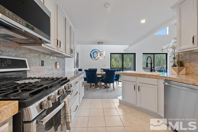 kitchen featuring white cabinetry, appliances with stainless steel finishes, and tasteful backsplash