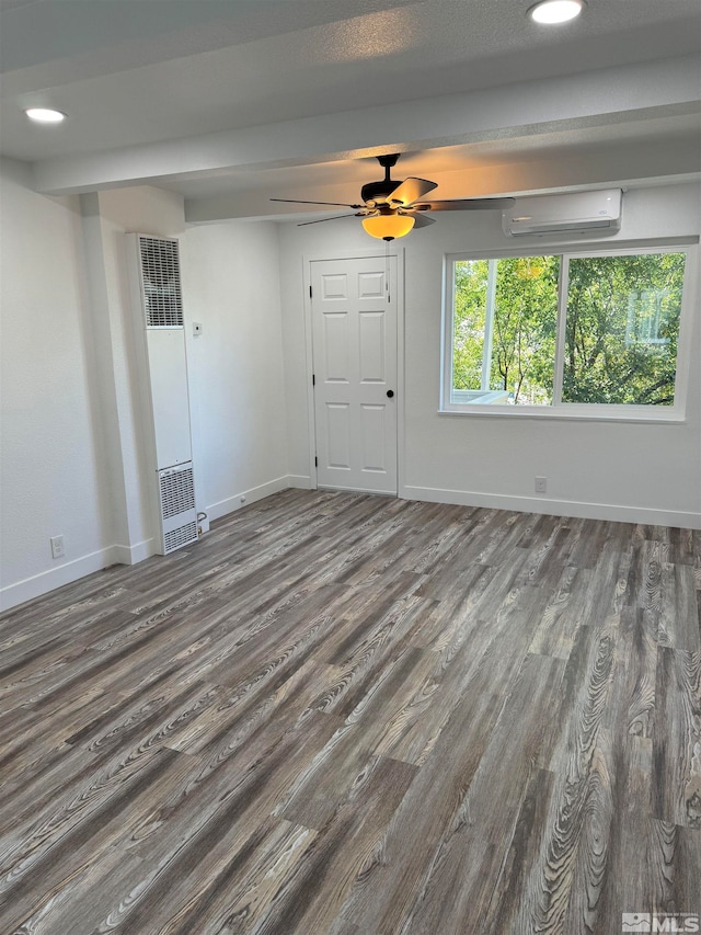 empty room featuring dark hardwood / wood-style floors, ceiling fan, and an AC wall unit