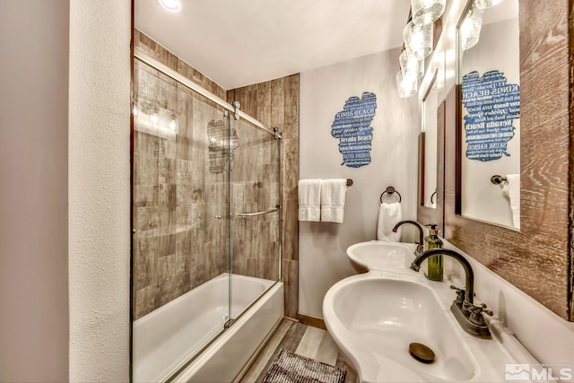 bathroom featuring shower / bath combination with glass door and sink