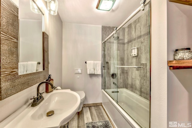 full bathroom featuring sink, toilet, and enclosed tub / shower combo