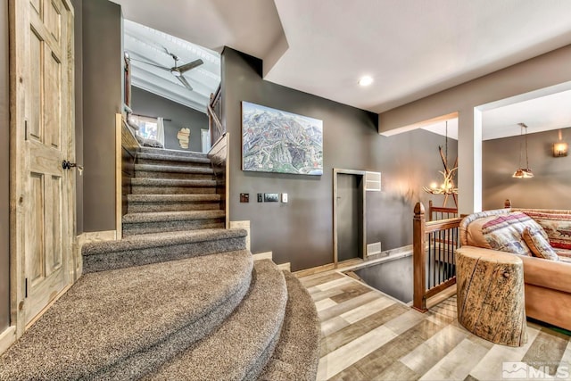 staircase with lofted ceiling with beams, light wood-type flooring, and ceiling fan with notable chandelier