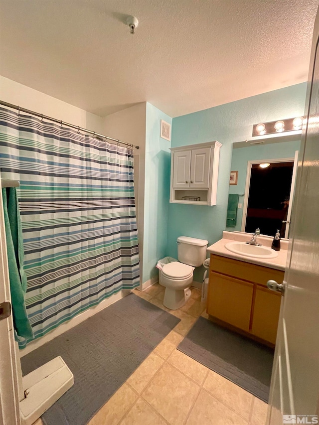 bathroom with tile floors, toilet, oversized vanity, and a textured ceiling