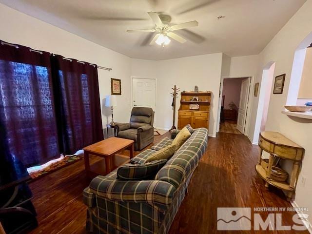 living room featuring ceiling fan and dark hardwood / wood-style flooring