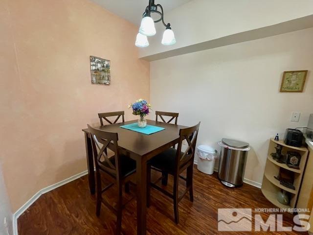 dining room with dark hardwood / wood-style floors and a notable chandelier