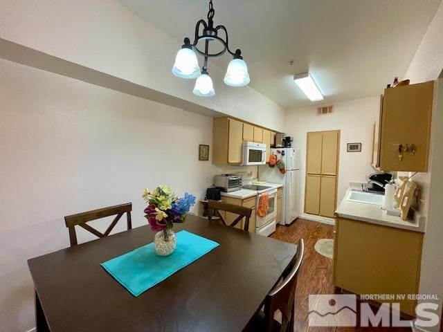 dining space featuring an inviting chandelier, dark hardwood / wood-style floors, and sink