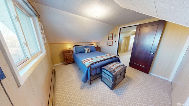 carpeted bedroom with a baseboard radiator and lofted ceiling