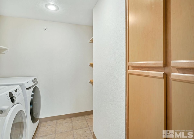 laundry room featuring light tile flooring and washer and dryer