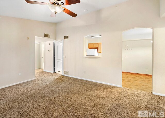 carpeted empty room featuring high vaulted ceiling and ceiling fan