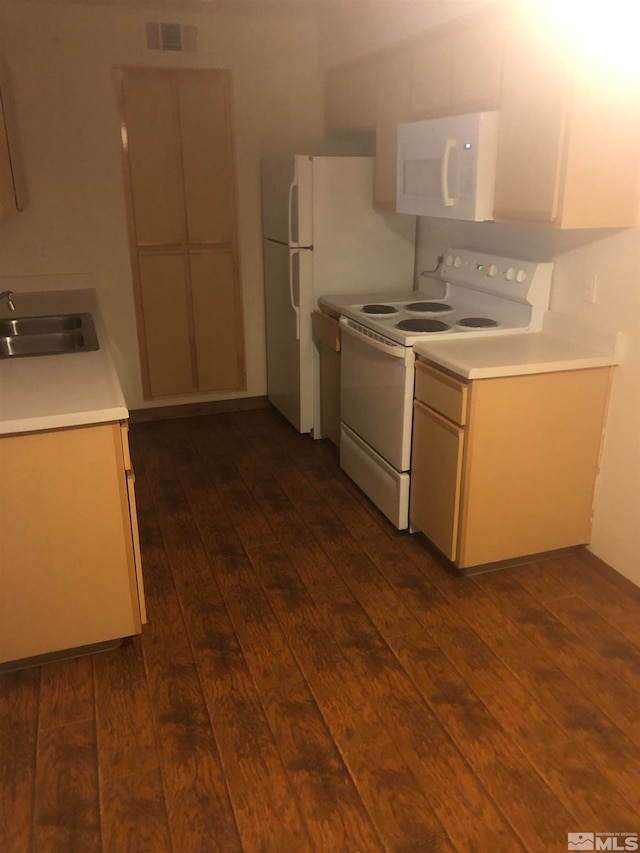 kitchen featuring white appliances, sink, and dark wood-type flooring