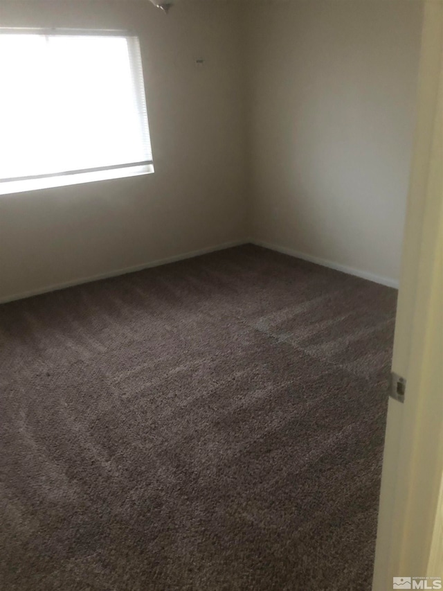 empty room featuring dark carpet