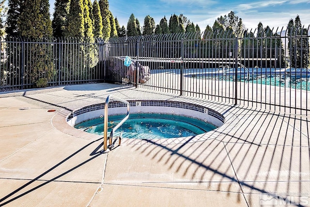 view of swimming pool with a community hot tub and a patio area