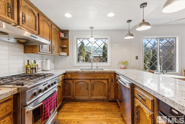 kitchen featuring decorative light fixtures, range with gas cooktop, light hardwood / wood-style floors, sink, and dishwasher