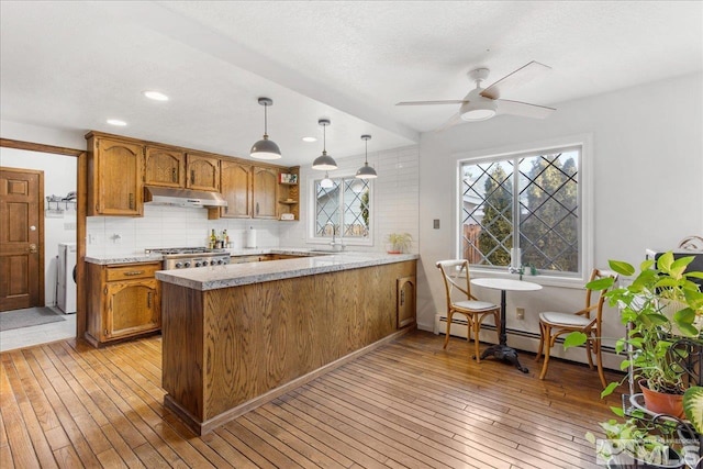 kitchen featuring decorative light fixtures, ceiling fan, light hardwood / wood-style flooring, and kitchen peninsula