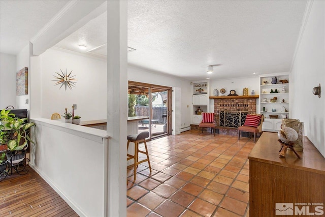 living room featuring crown molding, tile flooring, a fireplace, a textured ceiling, and built in shelves