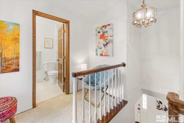 corridor featuring a chandelier and light carpet